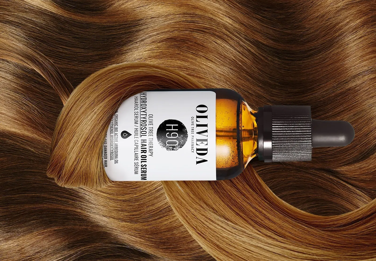 Oliveda H90 Hydroxytyrosol Hair Oil Serum bottle resting on glossy hair