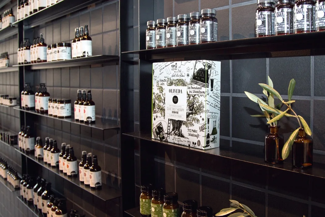 Black shelving full of Oliveda products in the Oliveda Düsseldorf store