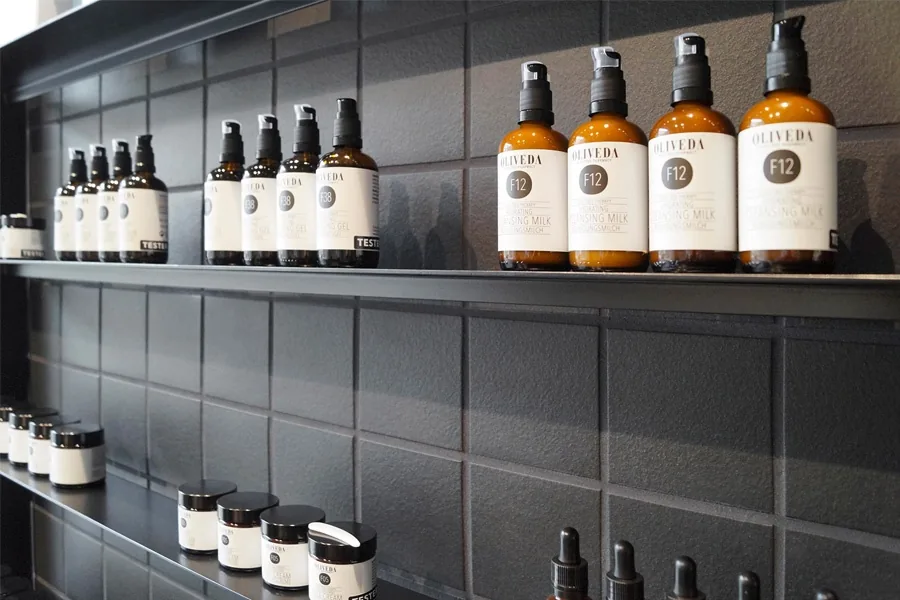 Oliveda pump bottles and jars on black tiled shelves
