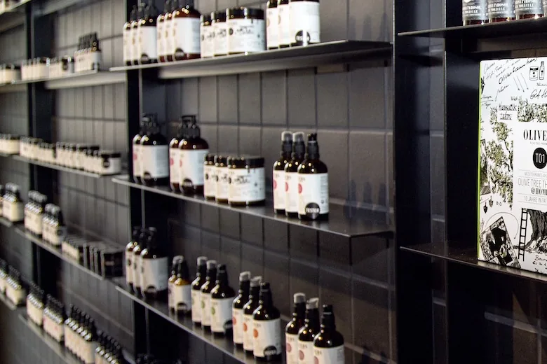 Rows of Oliveda bottles on black shelves